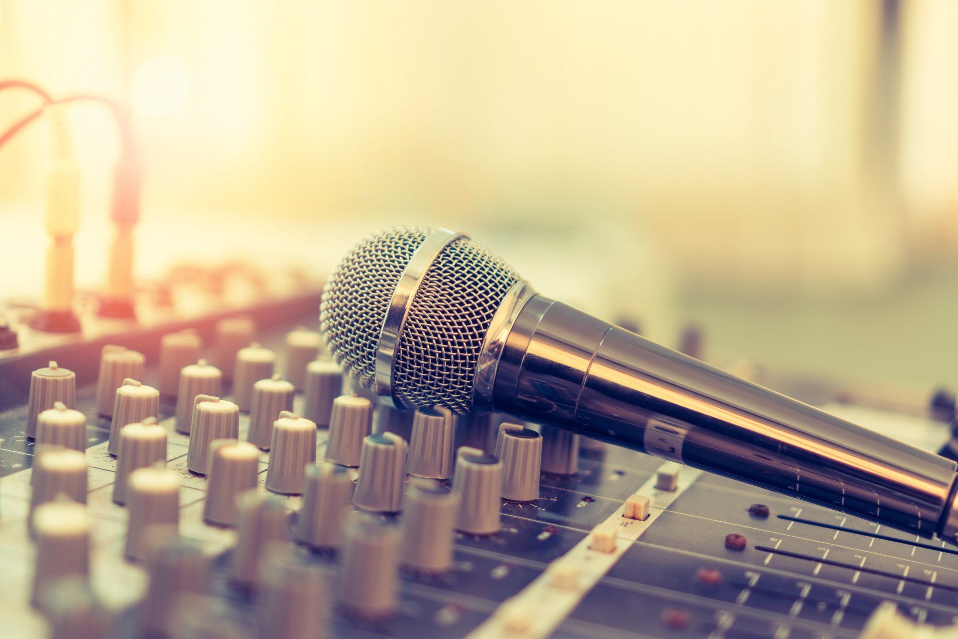 A microphone is sitting on top of a mixer.