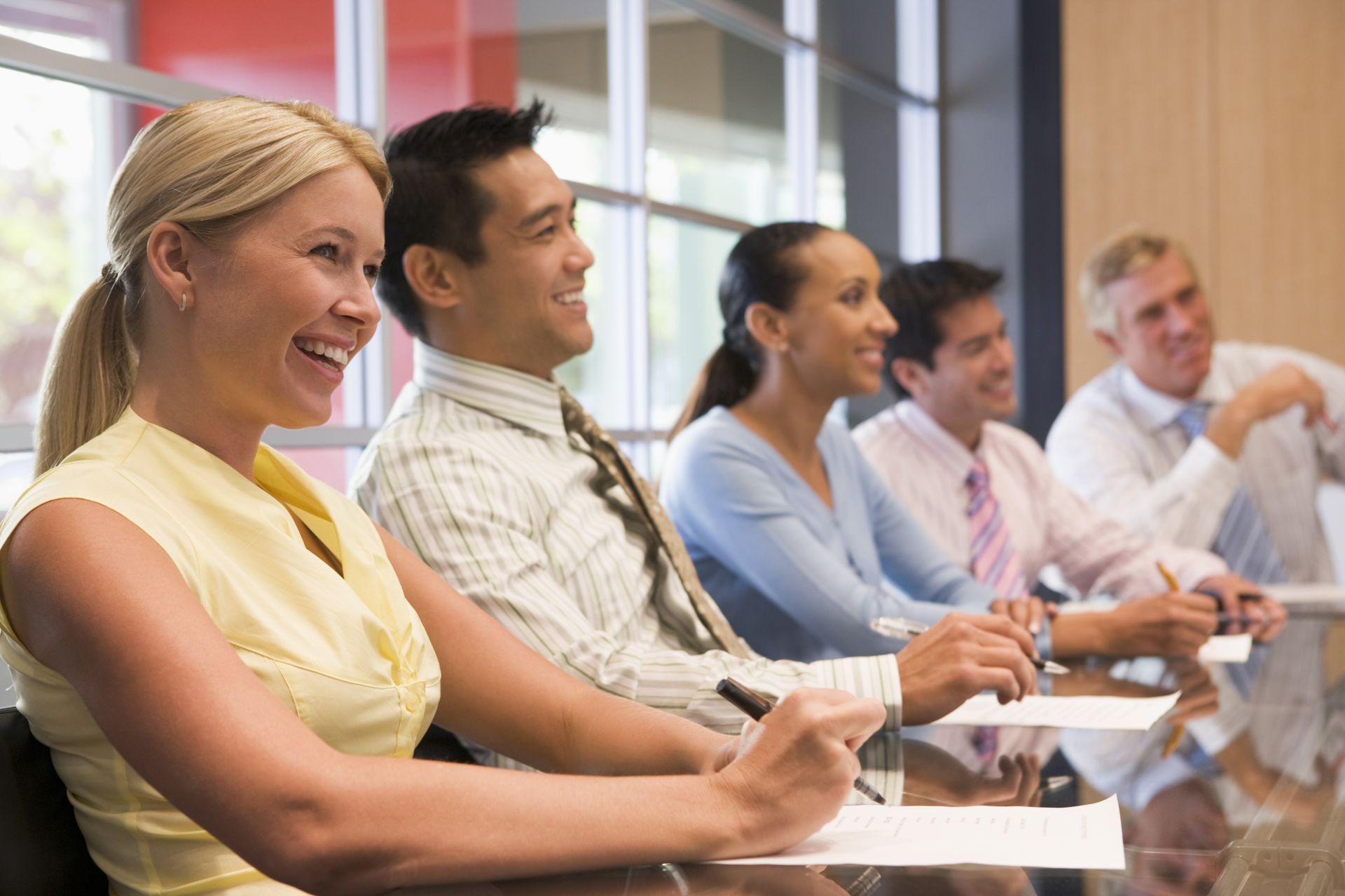 A group of people are sitting at a table in a conference room.