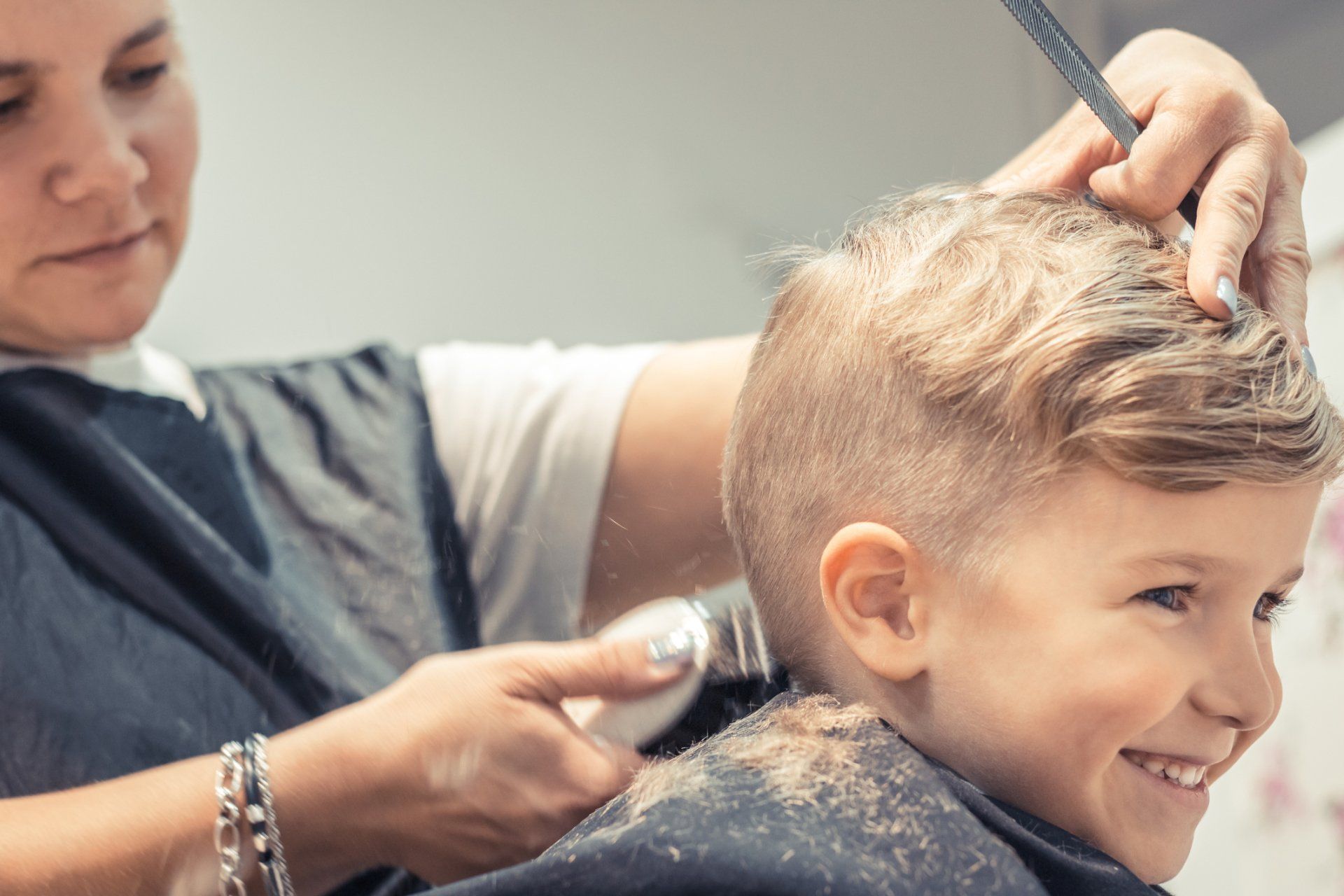 Barbershop Wilmington — Happy Kid Getting Haircut at Hairdresser's in Wilmington, DE