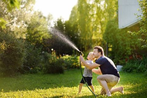 Father and Son Playing Water on the Lawn — Oldsmar, FL — The Spray Doctor Father and Son Playing Water on the Lawn — Oldsmar, FL — The Spray Doctor