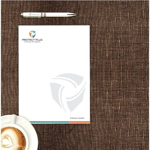 Um papel timbrado está sobre uma mesa ao lado de uma xícara de café e uma caneta.