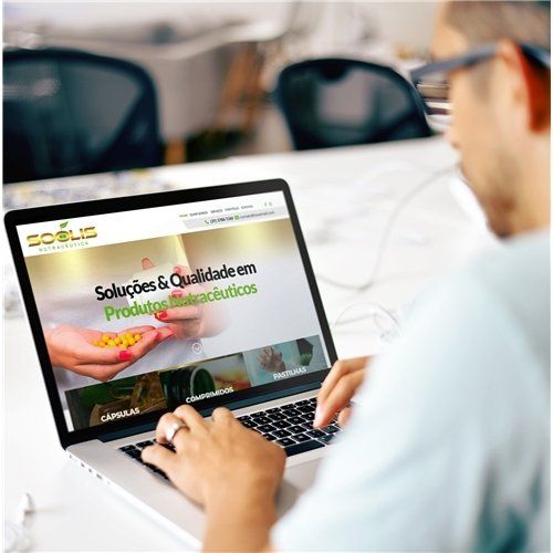 Um homem está usando um laptop com um site na tela.