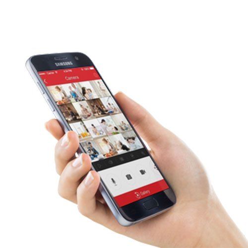 Hand holding a smartphone displaying a security camera app feed with multiple camera views.