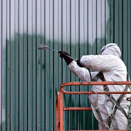 Painter in suit spray painting exterior wall painter in suit spray painting exterior wall