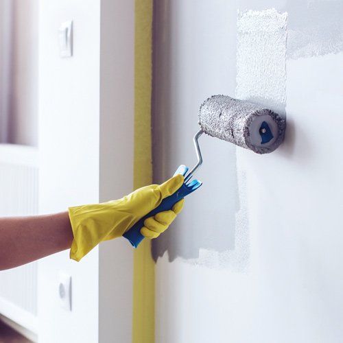 Person painting wall with paint roller person painting wall with paint roller