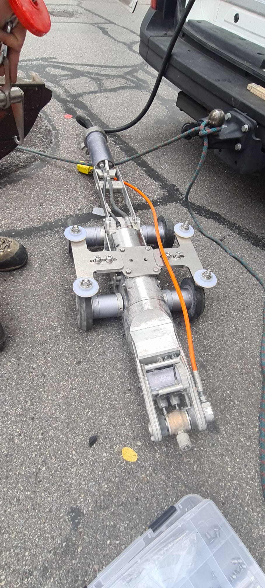 Un robot est assis sur le sol à côté d'une voiture.
