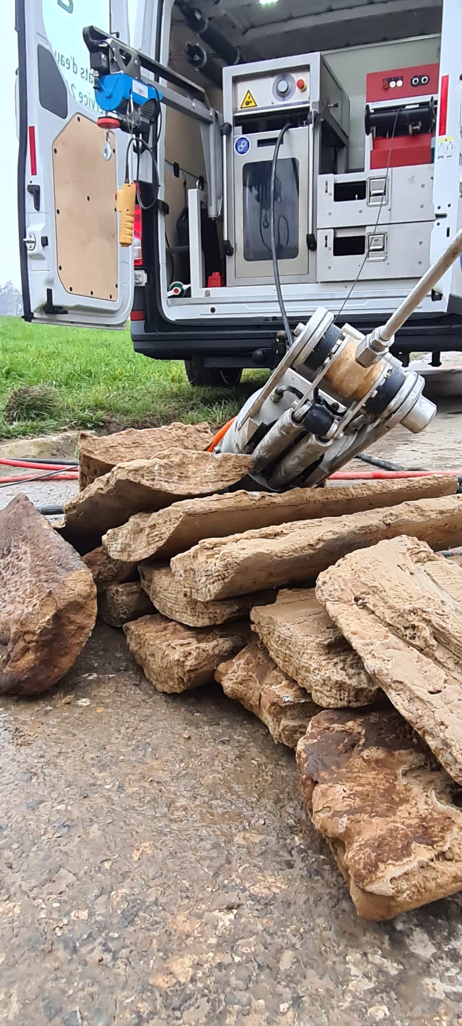 Un tas de bois est posé sur le sol devant une camionnette.