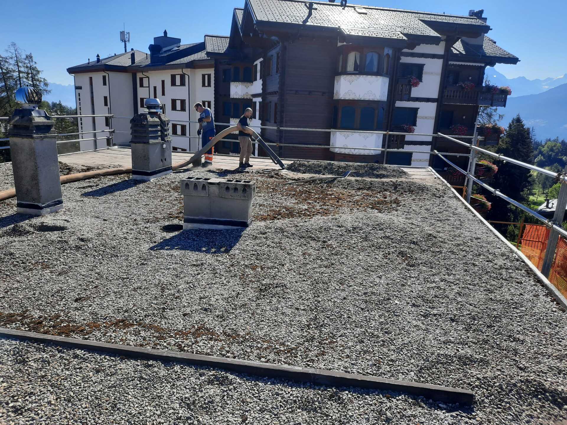 Un grand bâtiment avec un toit en gravier devant lui