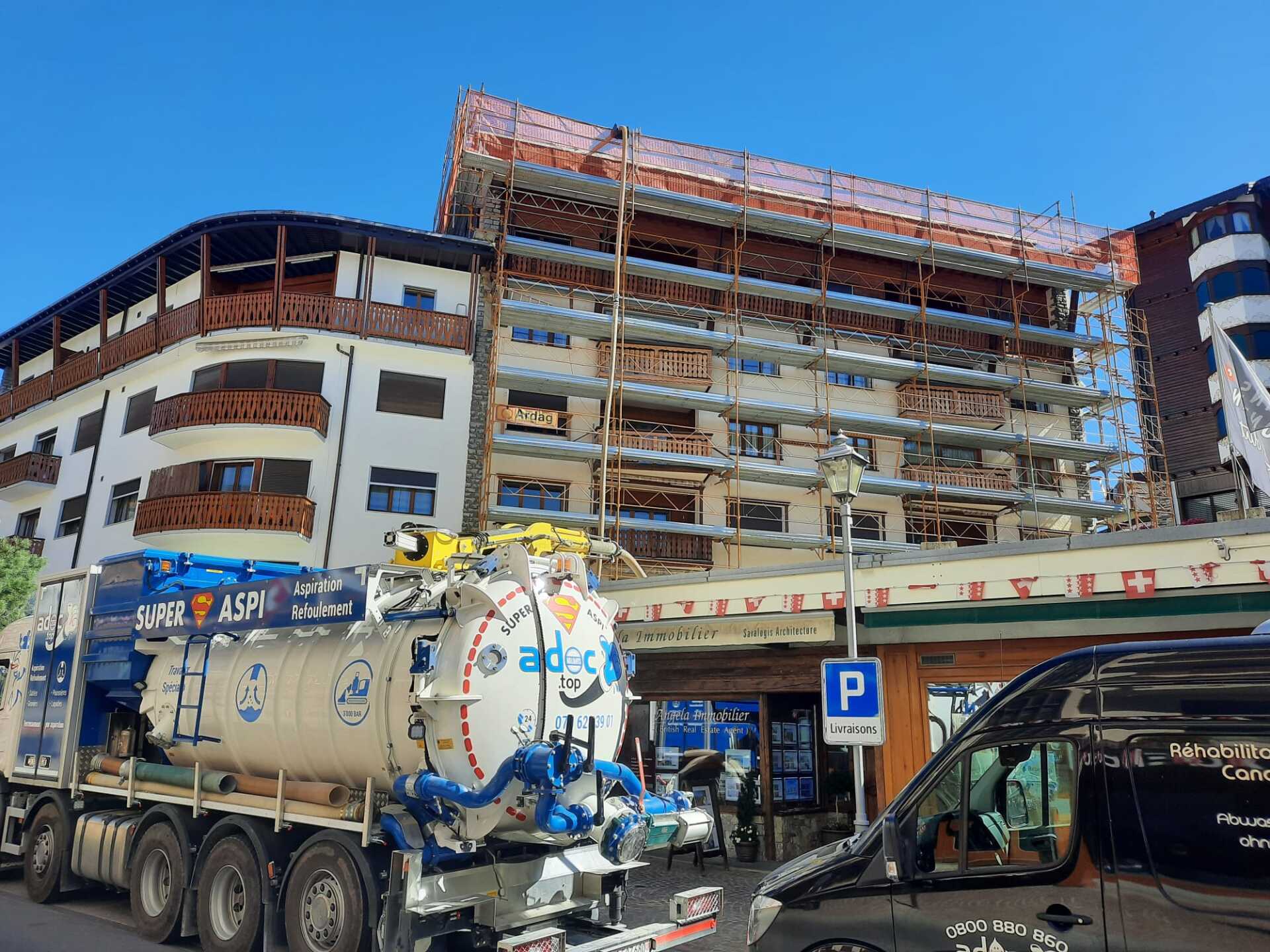 Un gros camion est garé devant un bâtiment en construction.