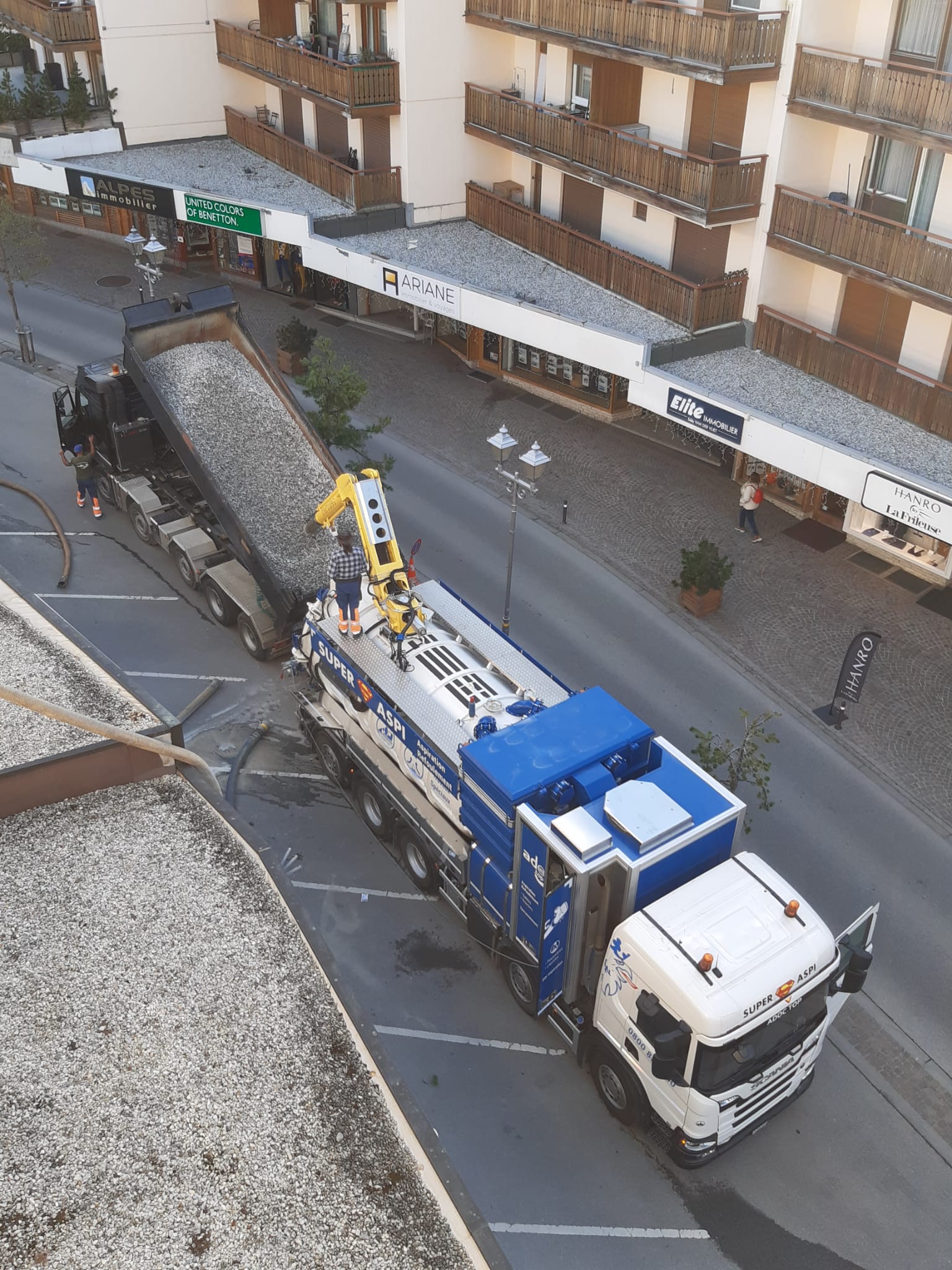 Un camion bleu et blanc est garé sur le bord de la route