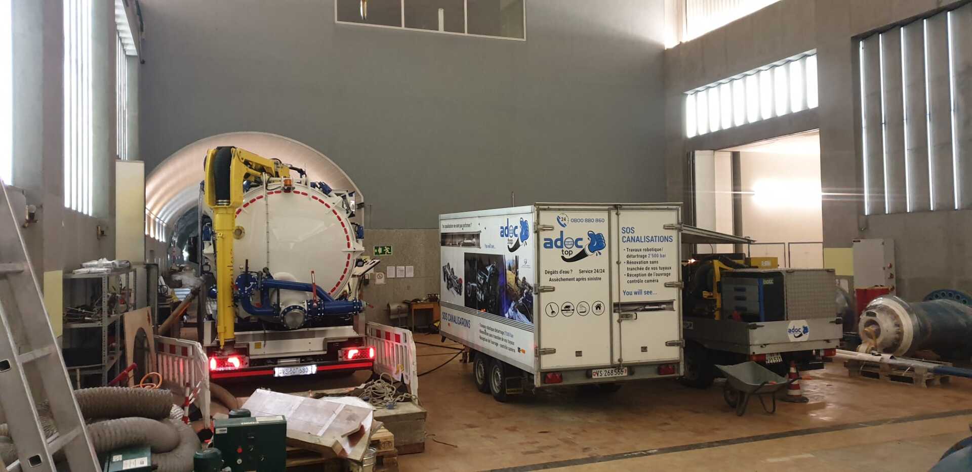 Un camion est garé dans un garage à côté d'un autre camion.