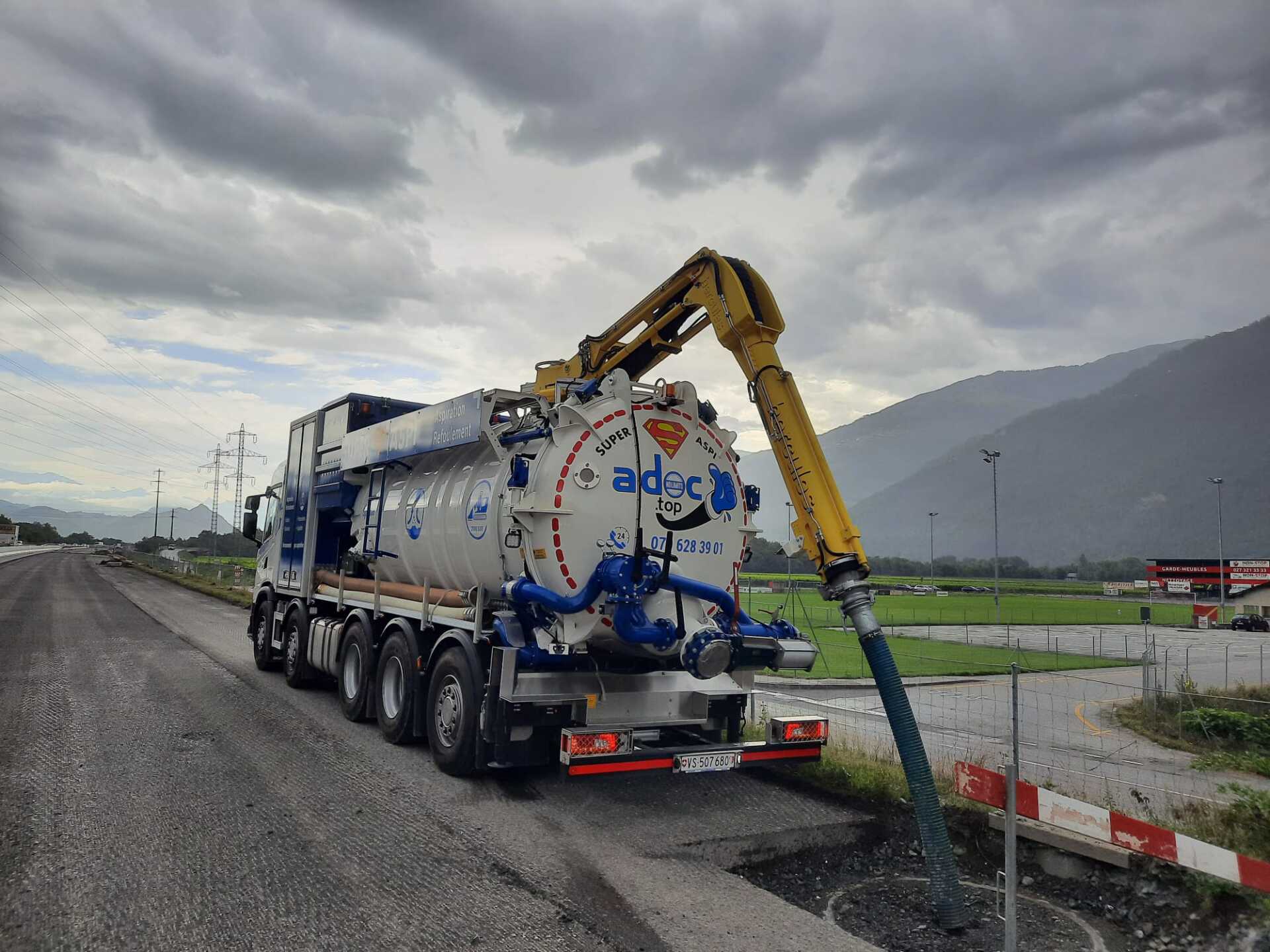 Un camion aspirateur est garé sur le bord de la route.