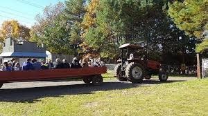 A group of people are riding on a tractor pulling a trailer.