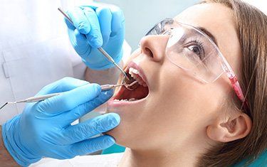 Root Canal Procedure — Woman Getting Root Canal Treatment in Kalamazoo, MI Root Canal Procedure — Woman Getting Root Canal Treatment in Kalamazoo, MI