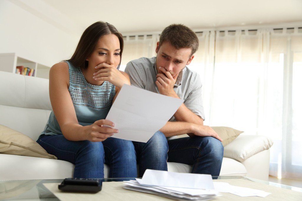 Credit Card Debt — Worried Couple Reading a Document in Aiken, SC Credit Card Debt — Worried Couple Reading a Document in Aiken, SC