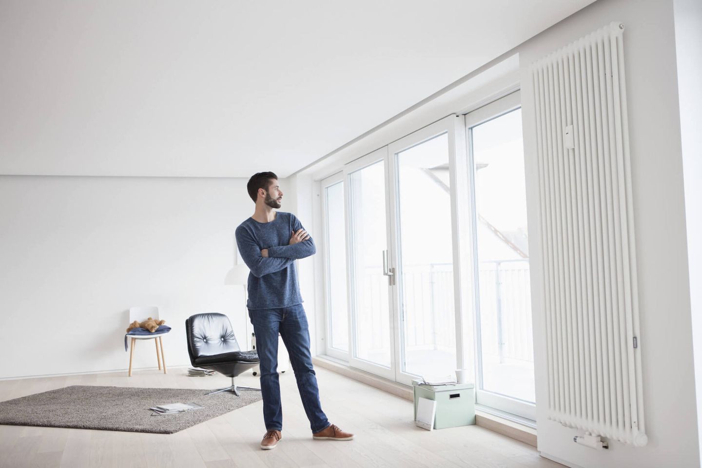 a man standing in a room and looking out of the window