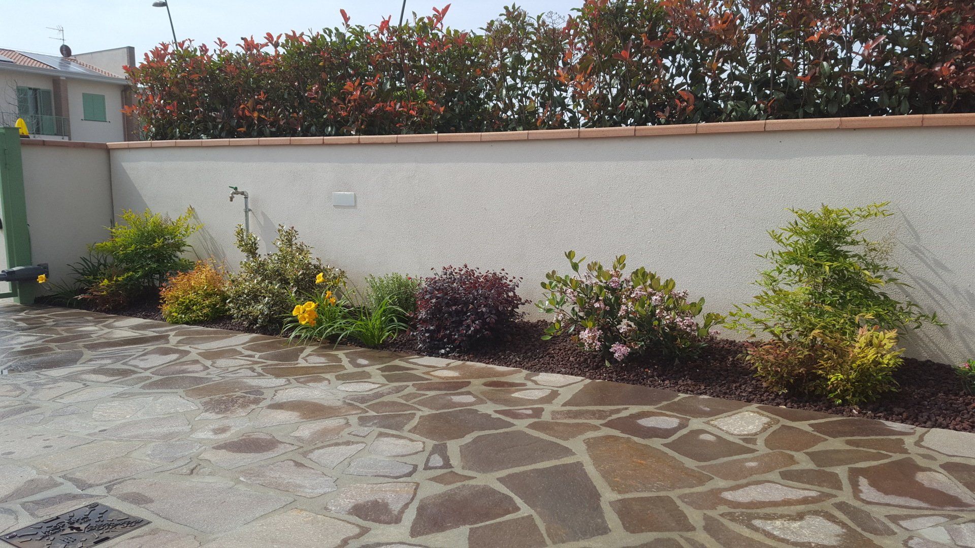 villa con aiuola e muro di recinzione con fiori
