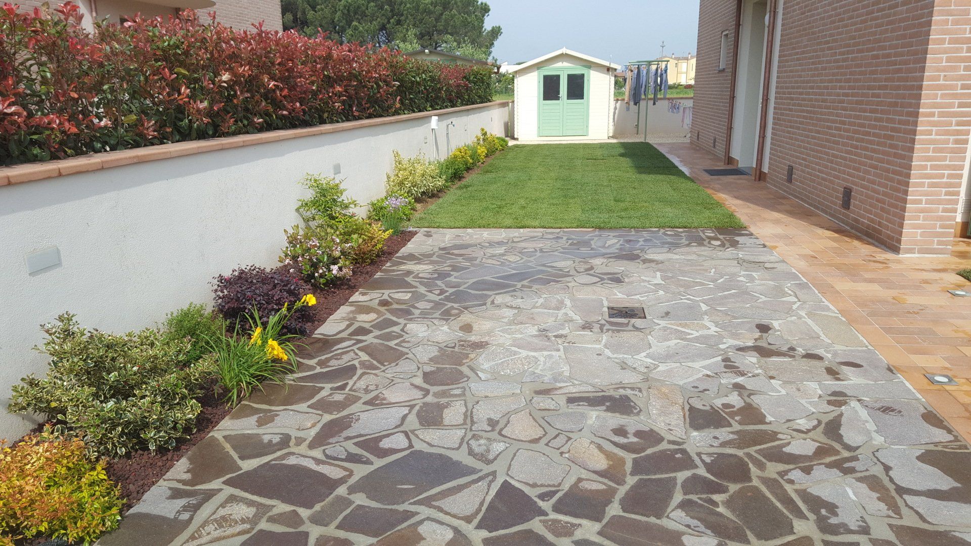 villa con giardino e muro di recinzione con fiori