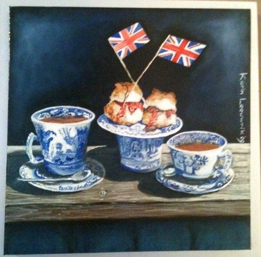 Blauw-witte theekopjes en een dessert op een tafel, met twee kleine Britse vlaggetjes tegen een donkere achtergrond.