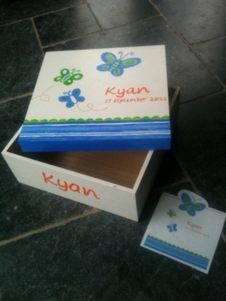 Decoratieve, gepersonaliseerde geschenkdoos en een blauw, groen en oranje bloemen