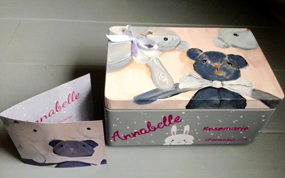 Gepersonaliseerde, versierde geschenkdoos en bijpassende container met roze en grijze bloemenaccenten.