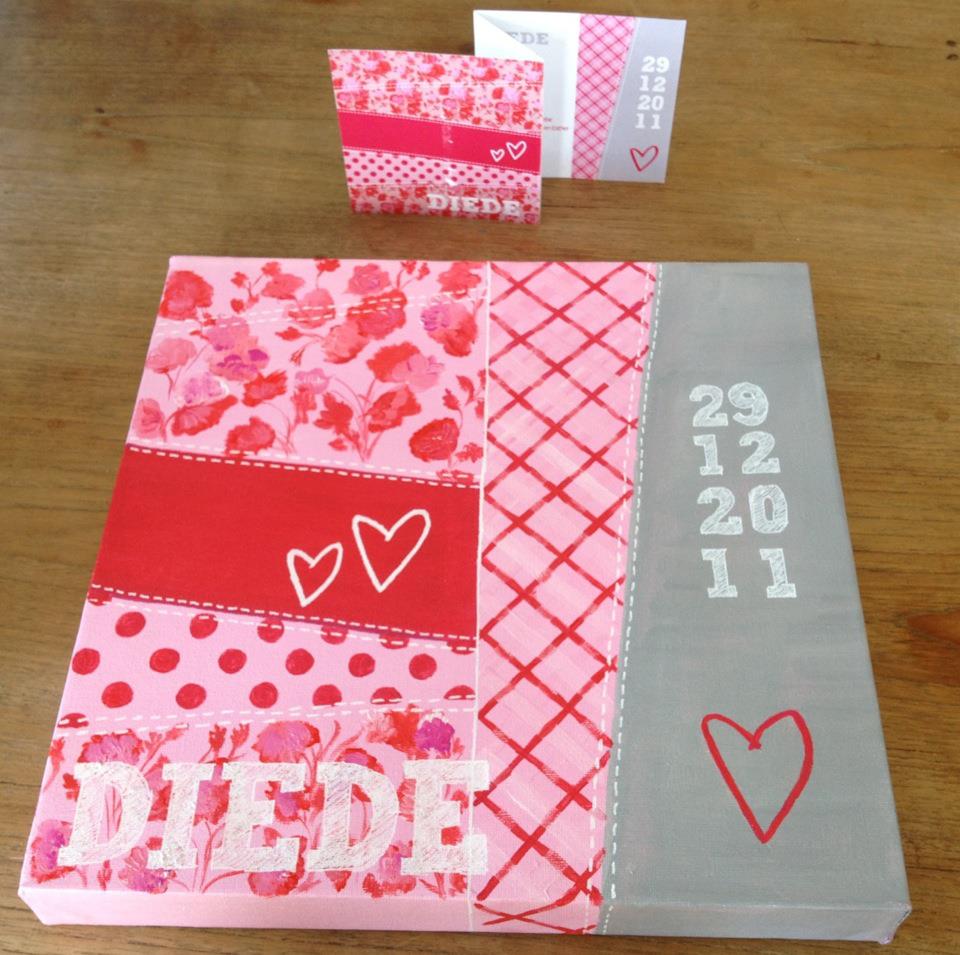 Roze-grijze handgemaakte kaart met hartjes en de datum 29-12-2011 op een houten tafel.