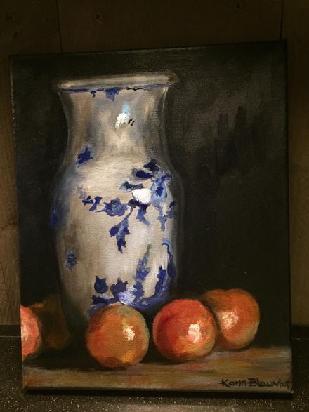 Blauw-witte vaas met sinaasappels op een donkere achtergrond, stilleven