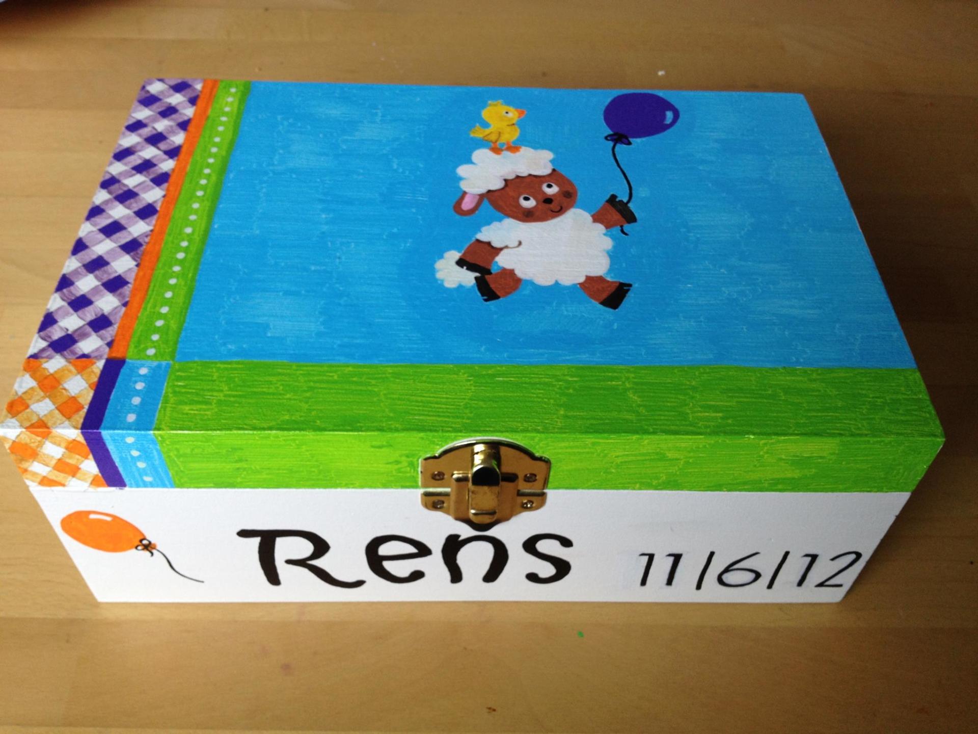 Versierde geschenkdoos met blauw deksel, schaapjes en een ballon, met het opschrift 