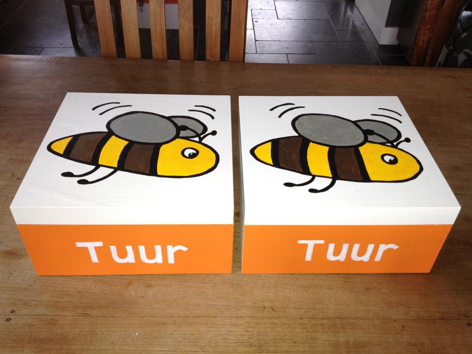 Twee witte dozen met cartoonbijen en het woord 