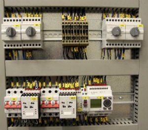 Electrical control panel with switches, circuit breakers, and wiring.