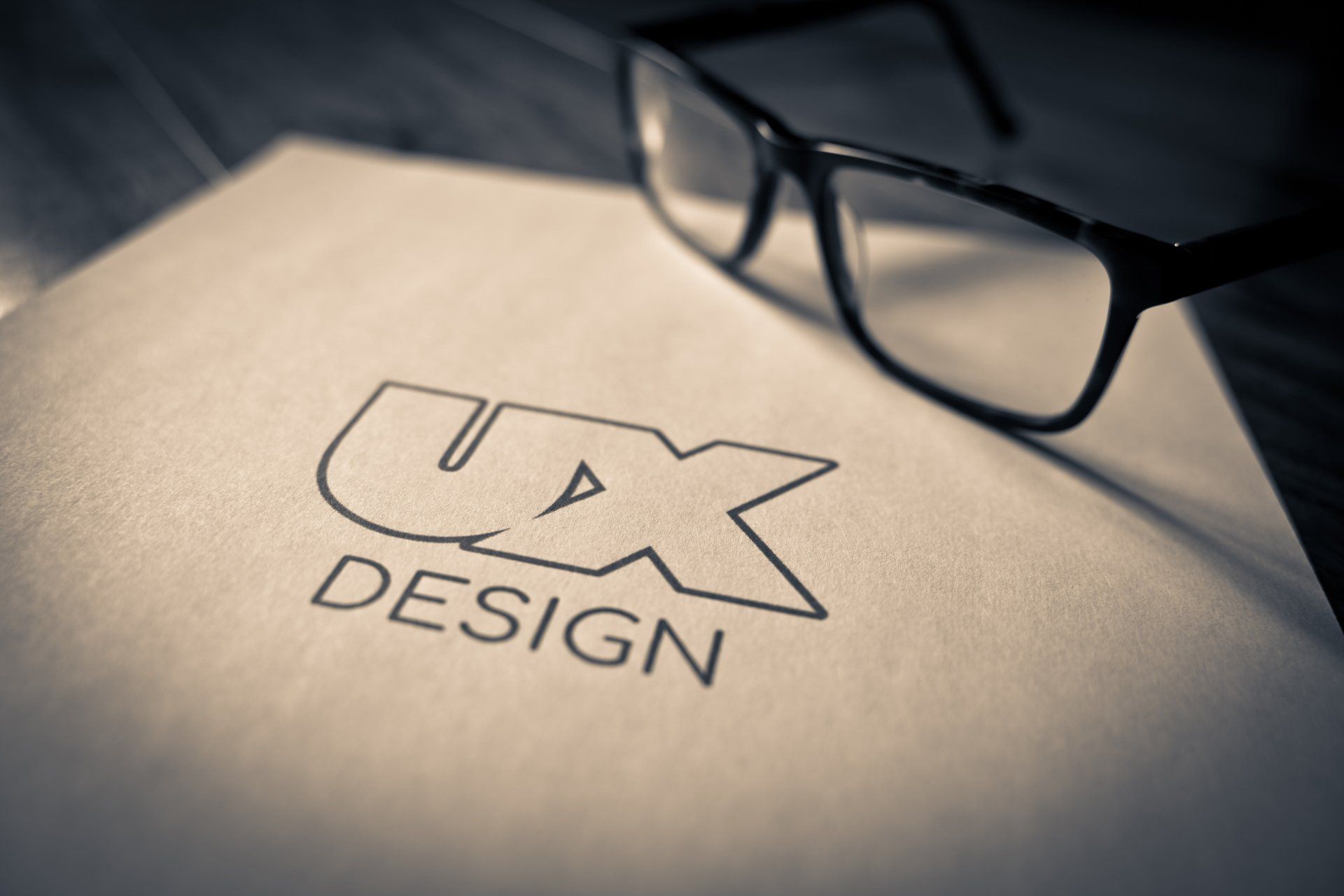 A pair of glasses sitting on top of a piece of paper that says ux design