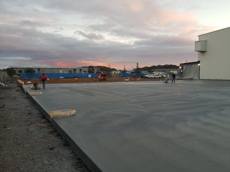 concrete workers on large slab of concrete