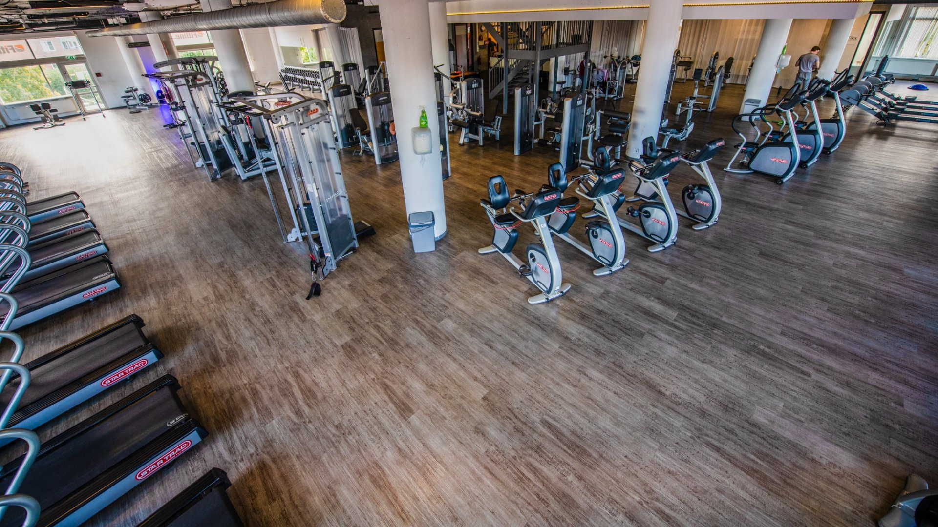 een luchtfoto van een sportschool vol loopbanden en hometrainers.