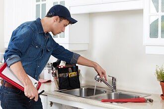Plumber Checking a Faucet — Plumbing Contractor in Sacramento, CA Plumber Checking a Faucet — Plumbing Contractor in Sacramento, CA
