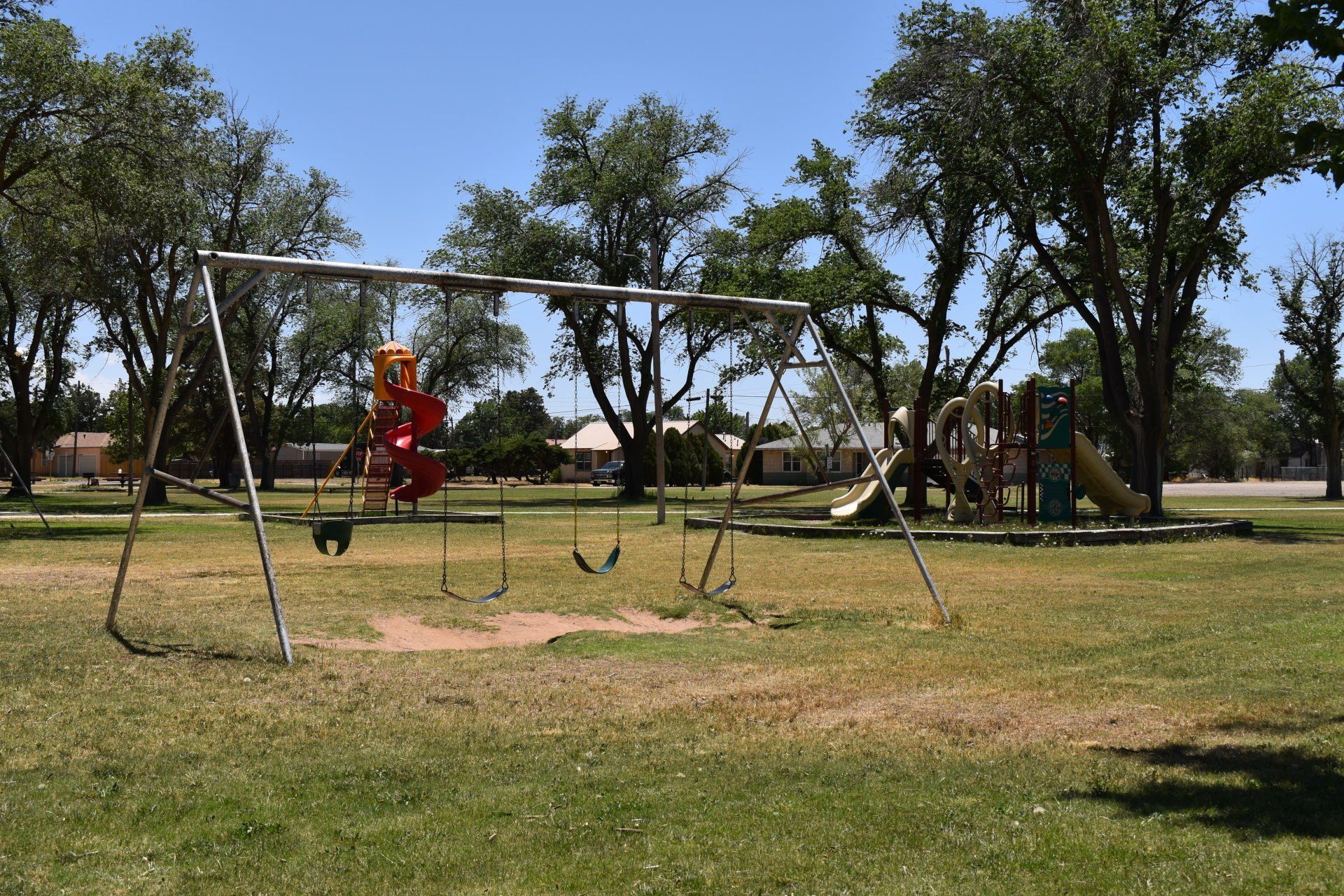 A playground with swings and a slide in a park