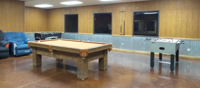 There is a pool table and a foosball table in the room.