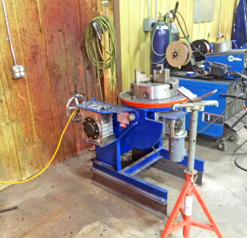 A machine is sitting on a red stand in a garage