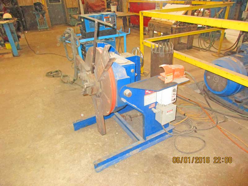A blue machine is sitting in a room with a yellow railing.