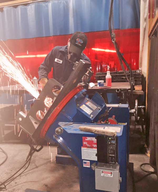 A man wearing a black hat is working on a machine