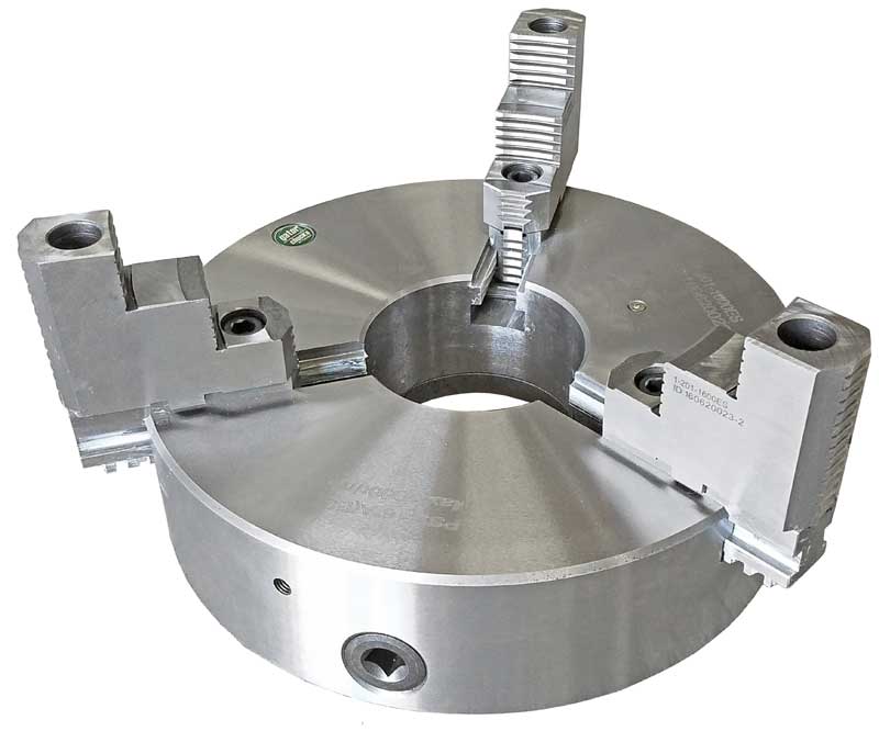 A close up of a lathe chuck on a white background.