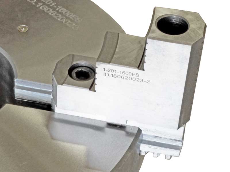 A close up of a lathe chuck with a hole in the middle