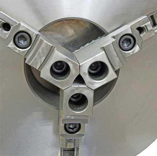 Welding Chuck A close up of a lathe chuck with three holes in it.