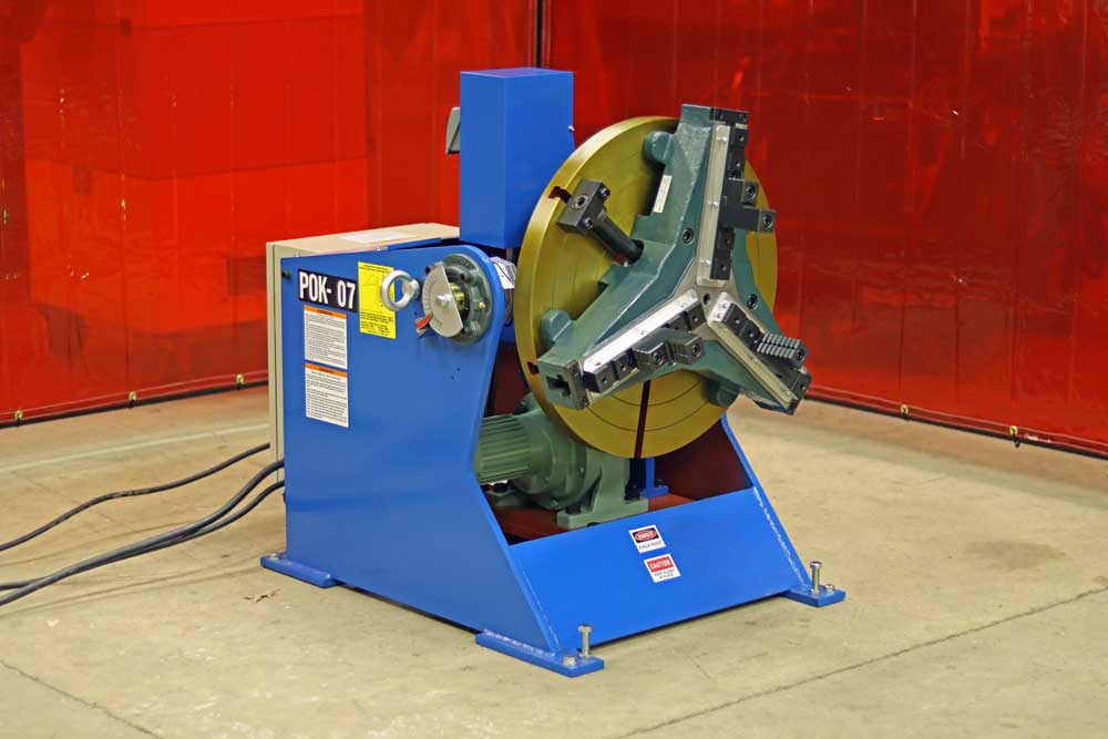 A machine is sitting on the floor in front of a red wall.