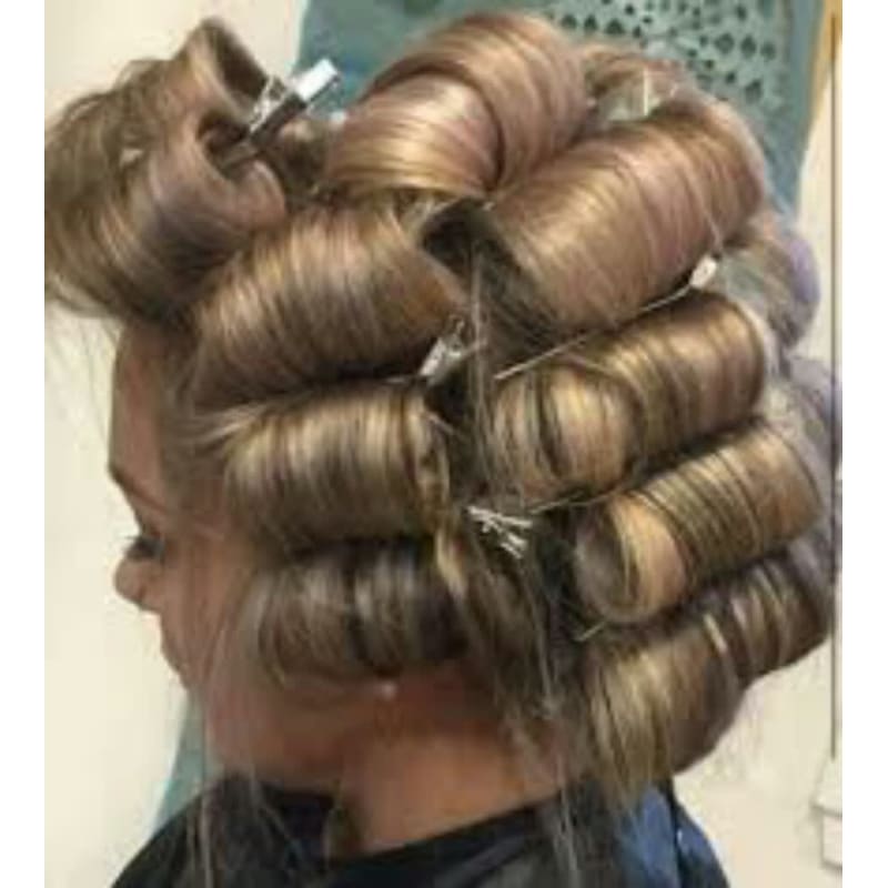 A woman is getting her hair curled with rollers.