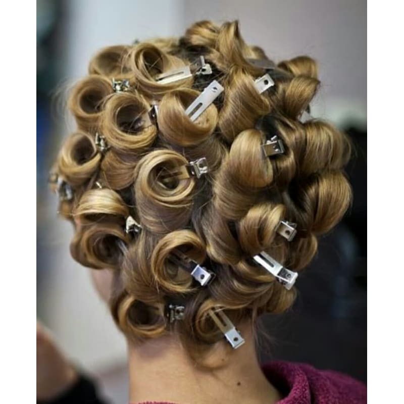 A woman has her hair in rollers and clips