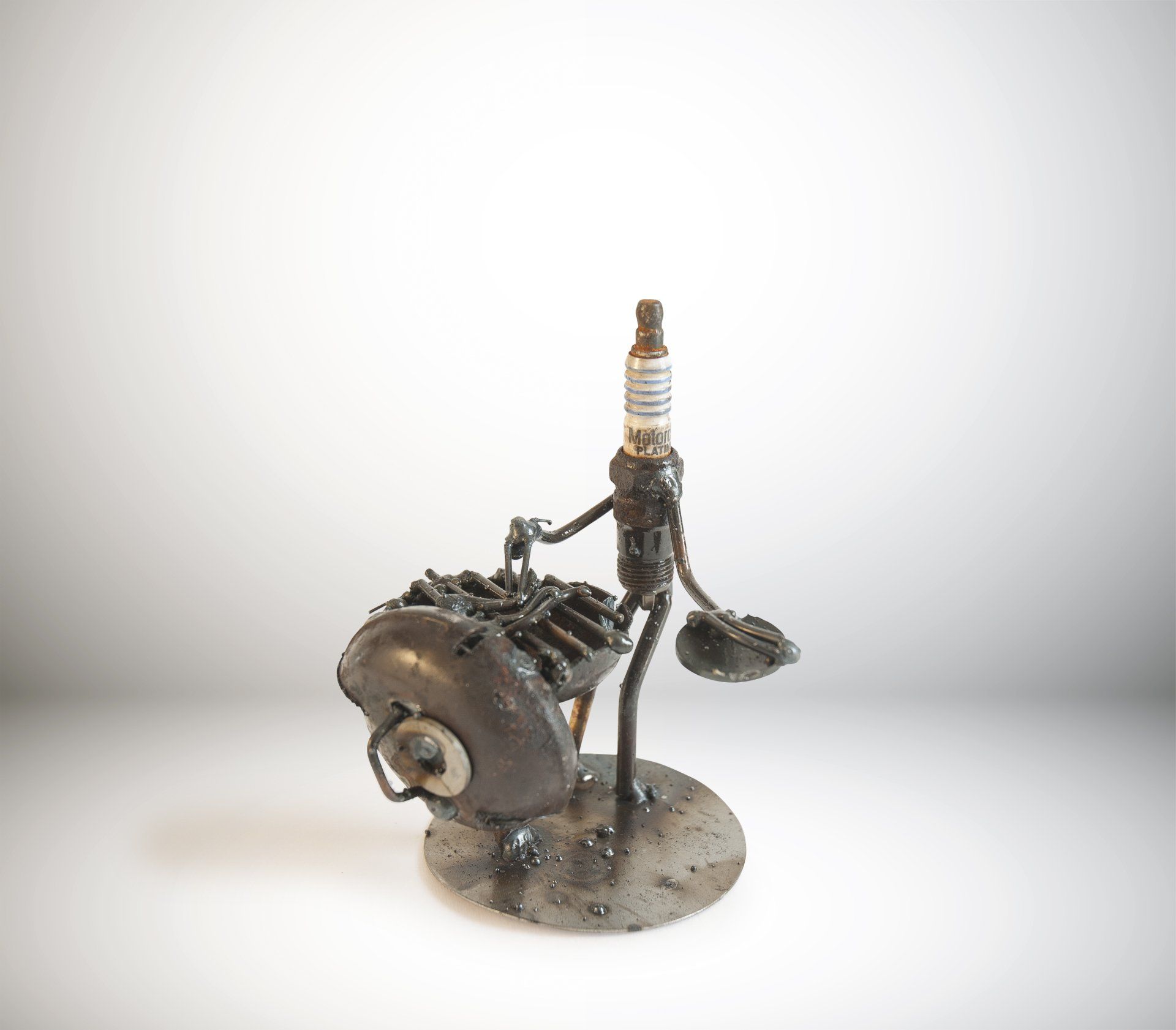 Sparkplug Sculpture of Figurine Grilling on Weber Grill