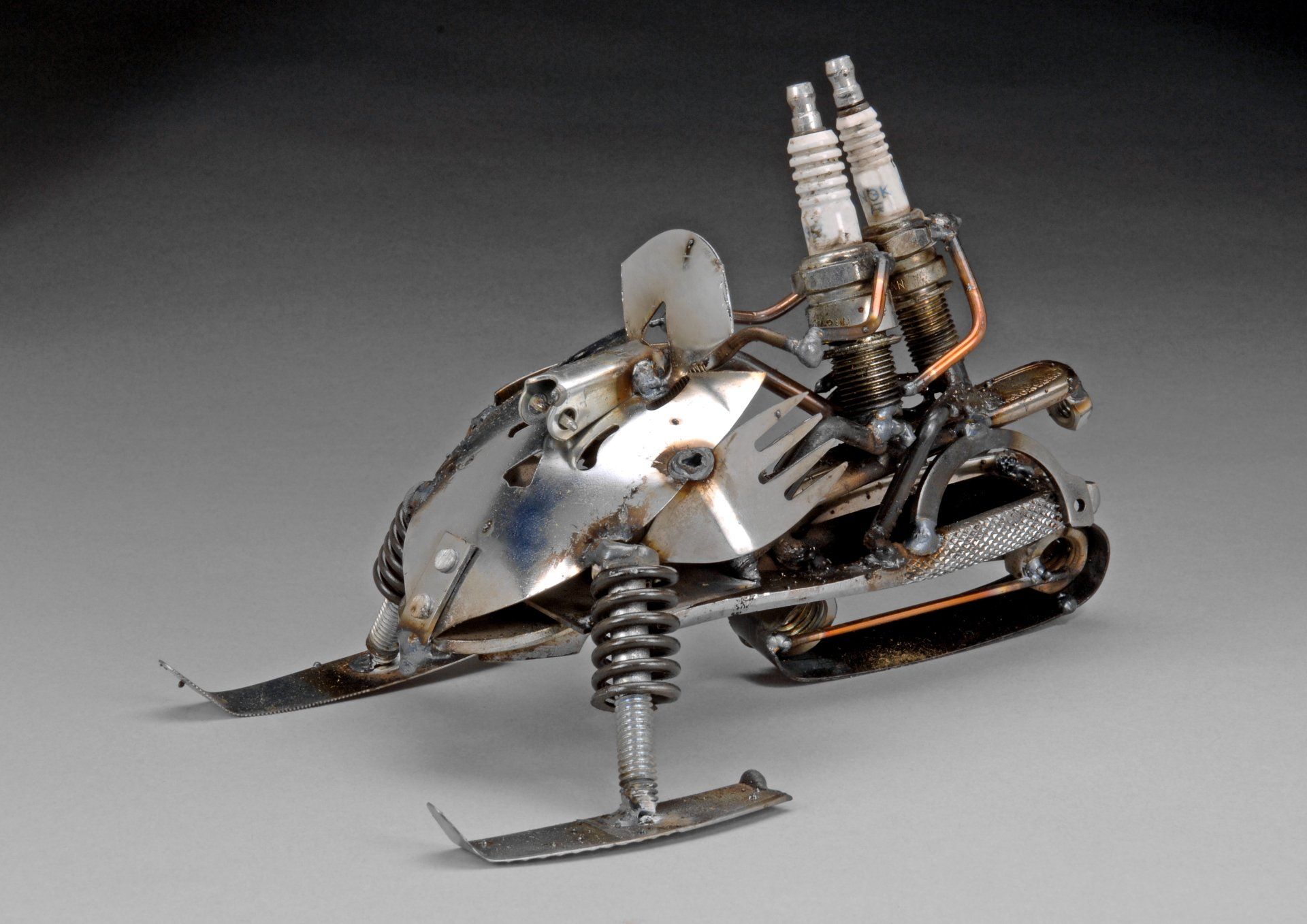 Sparkplug Sculpture of 2 Figures on Snowmobile