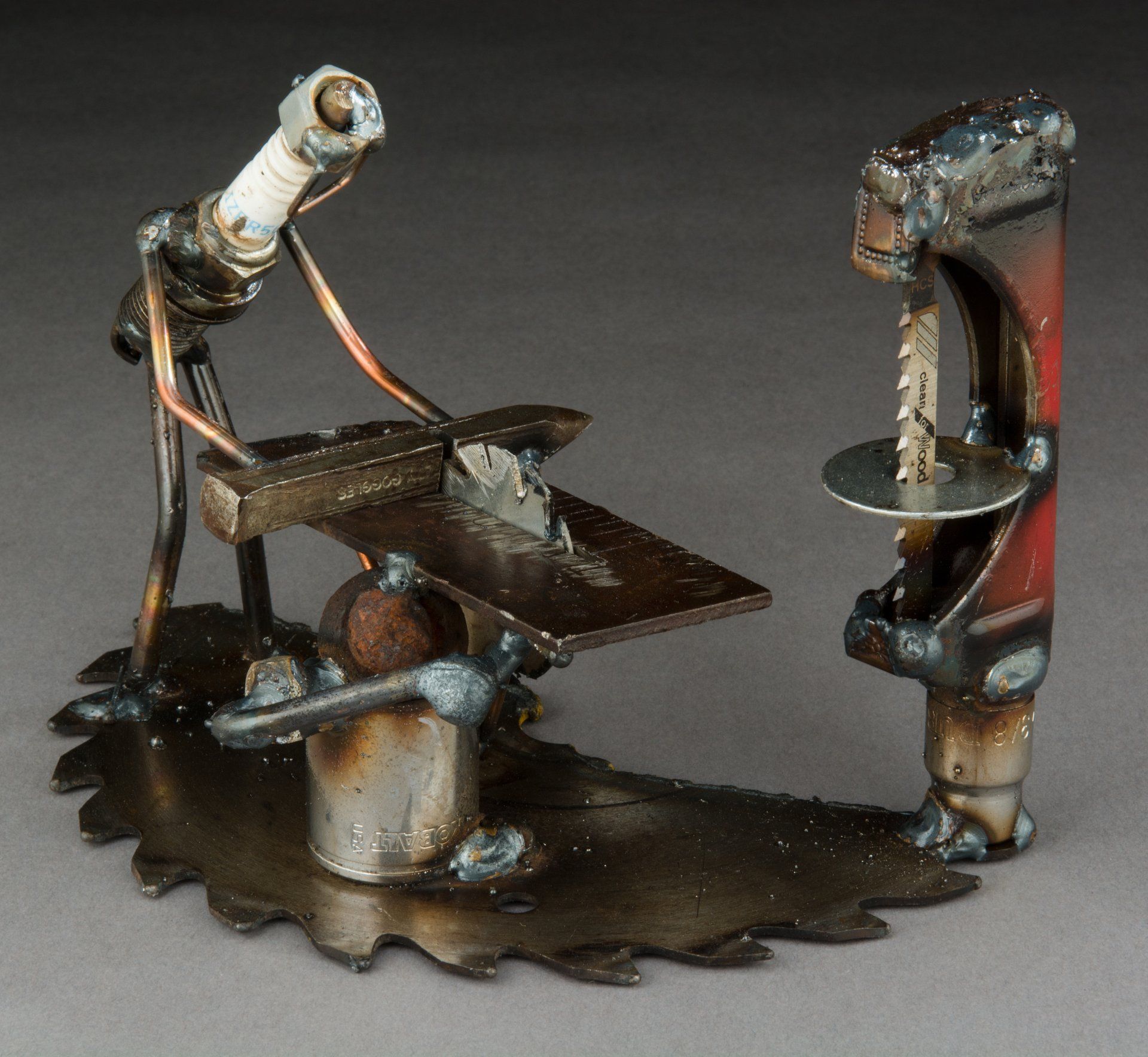 Sparkplug Sculpture of Figuring working in Woodshop