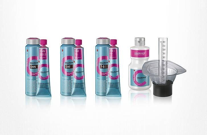 Kit per tinture per capelli: diverse bottiglie blu, tinta, strumenti di misurazione su bianco.