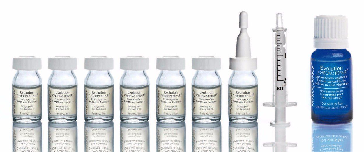 Fiale e siringhe mediche su una superficie bianca, probabilmente contenenti medicinali.